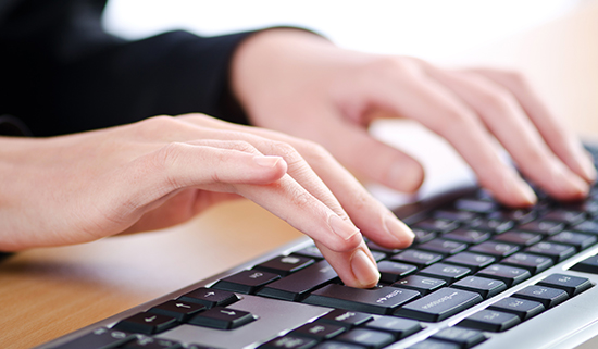 Image of close up of hands operating a keyboard