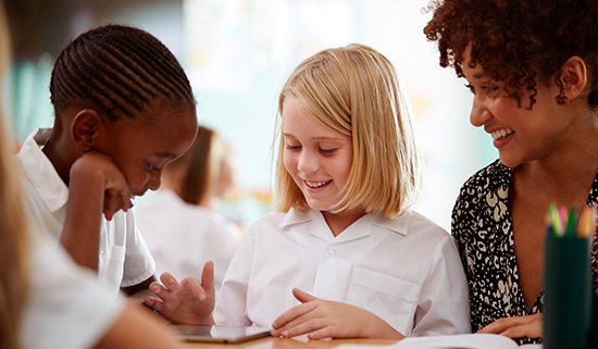 Image of two primary school aged children with a female teacher