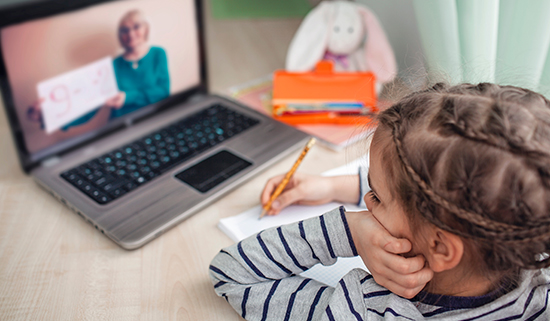 Image of young girl working on a laptop at home