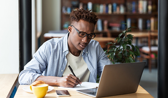 Image of man working at his desk using a laptop