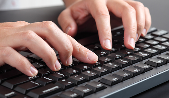 Image of close up of hands operating a keyboard