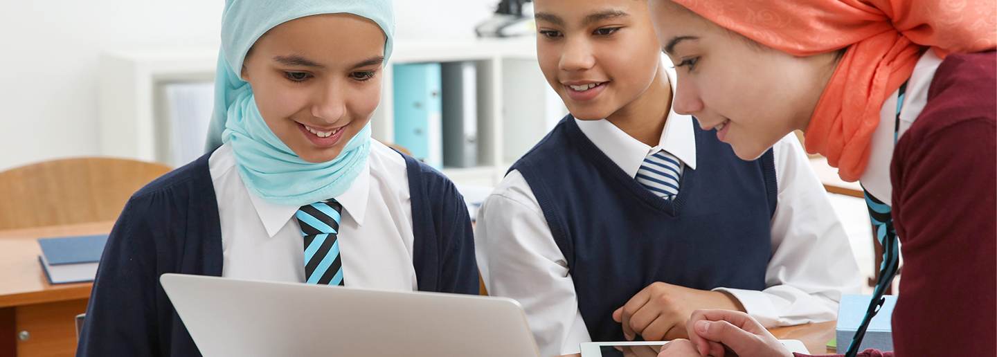 Image of three children together viewing a laptop screen