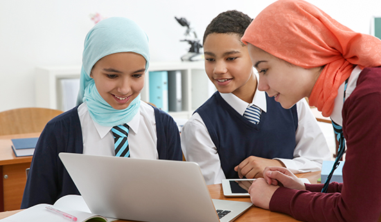 Image of three secondary school aged pupils viewing a laptop