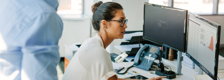 Image of a female business person viewing reports on a computer