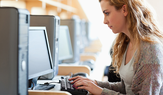 Female teacher operating a computer