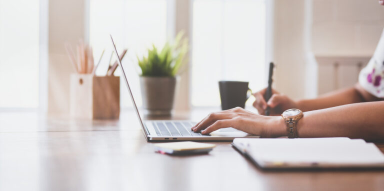 Side view of young businesswoman working on her laptop